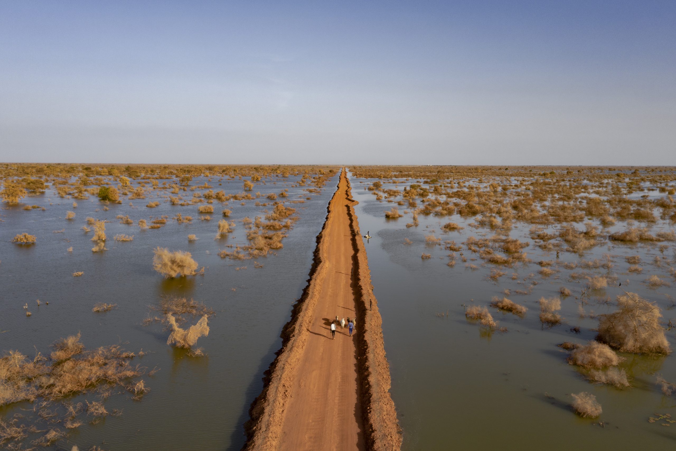 bentiu-south-sudan A road protected by dikes cuts through floodwater stretching to the horizon near the city of Bentiu, where over 360,000 people have been displaced by repeated severe flooding that has submerged homes and farmland.
