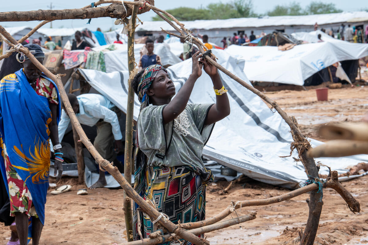 Sudanese refugee Bediria constructs a temporary shelter for her family at the UNHCR transit centre in Renk, Upper Nile State, South Sudan, which is hosting thousands of refugees and returnees. She and her family fled Sudan after the conflict broke out. High Commissioner Filippo Grandi visited South Sudan on a four-day mission in August.